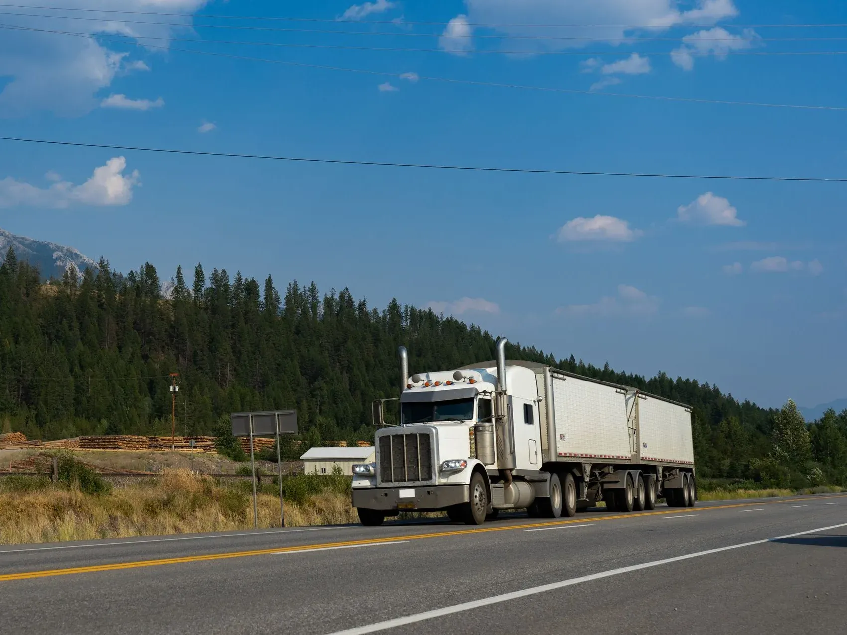 A clean white semi sleeper cab on the highway, the kind of truck Illyro drivers operate.
